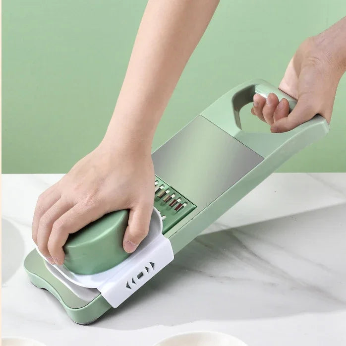 Green and white kitchen tool being used on a marble surface with a green background